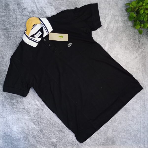Lacoste Negra con cuello Blanco y tiras negras