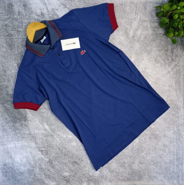 Lacoste Azul con tiras bordo en el cuello